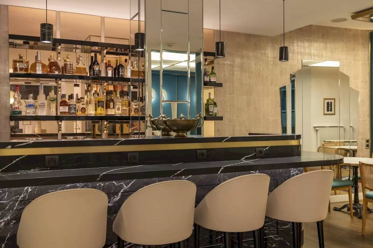 Barbereich des Victor Hugo Paris Kléber Hotels mit Marmortheke und Barhockern.