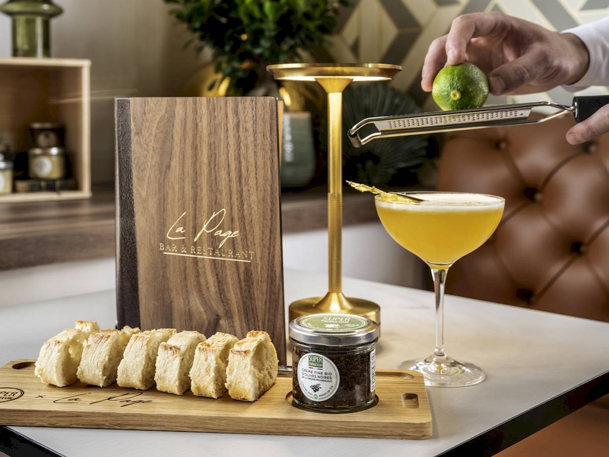 Ein Cocktail wird im Mercure Paris Bercy Bibliothèque zubereitet, mit einer Zitrone und einer Garnitur.