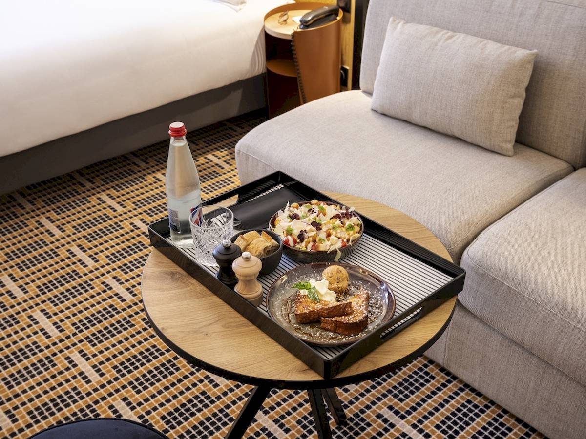 Frühstückstablett mit Toast, Salat und Getränk auf einem Tisch im Mercure Paris Bercy Bibliothèque Hotelzimmer