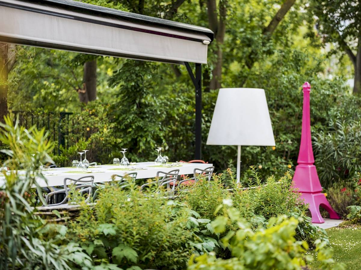 Außenbereich des Mercure Paris Centre Tour Eiffel mit Tisch, Stühlen und Gartendeko