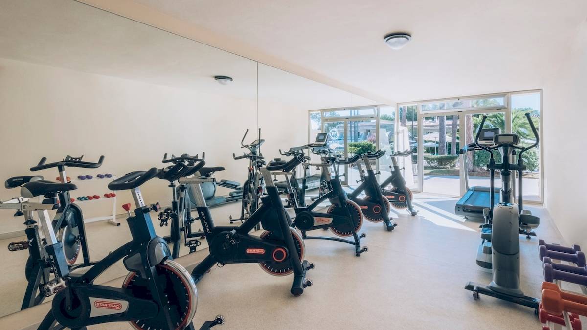 Fitnessstudio im Iberostar Waves Pinos Park Hotel mit Spinrädern und Laufbändern.