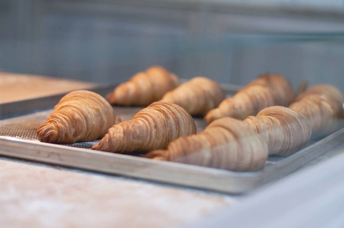Mehrere Croissants auf einem Tablett im Schaufenster eines Gebäckladens