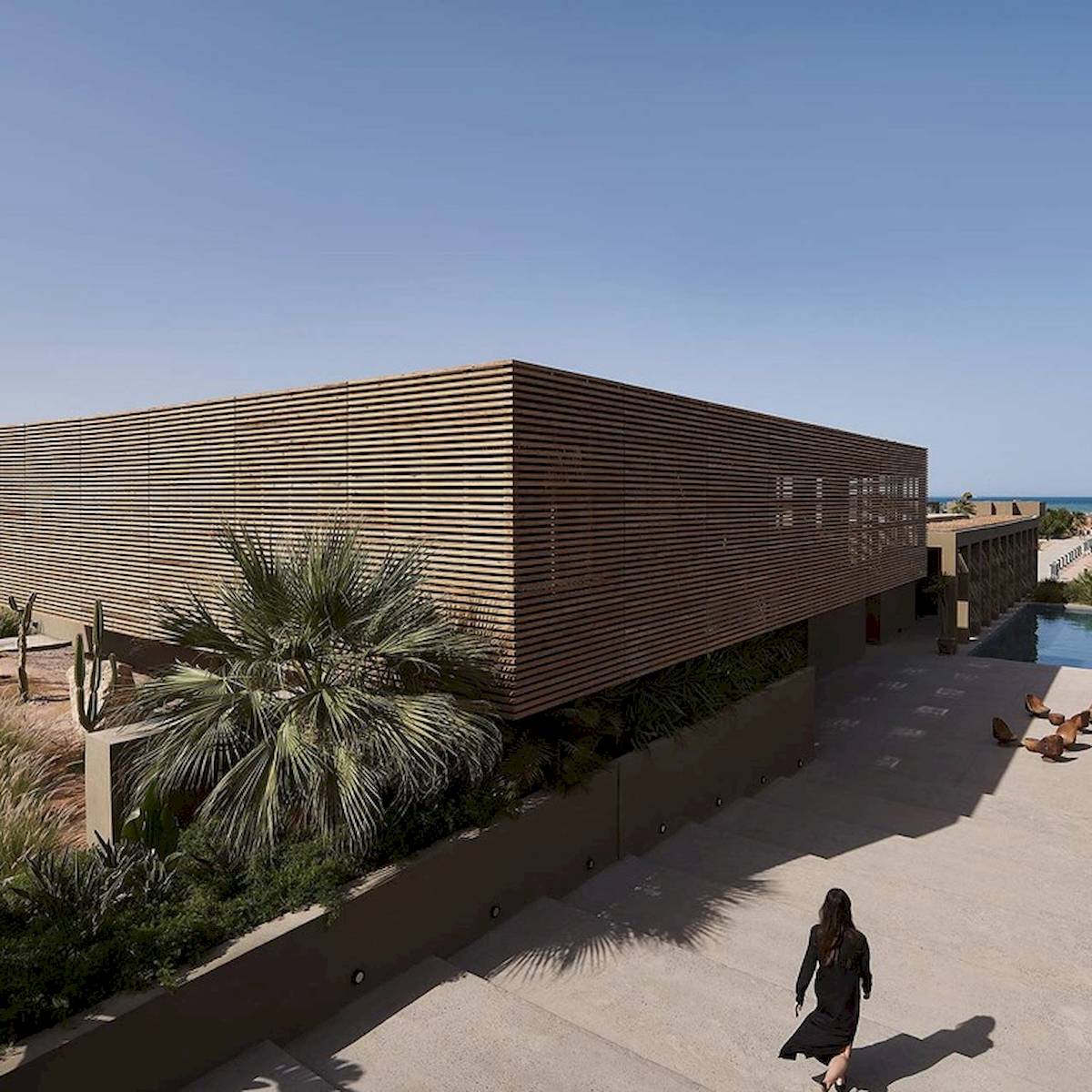 Außenansicht des Casa Cook El Gouna Hotels mit einer Frau, die einen schwarzen Rock trägt.