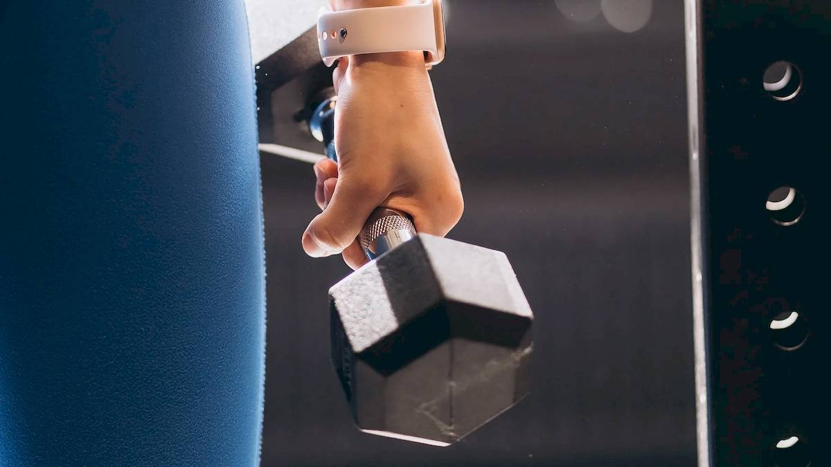 Person hebt eine Hantel im Fitnessstudio