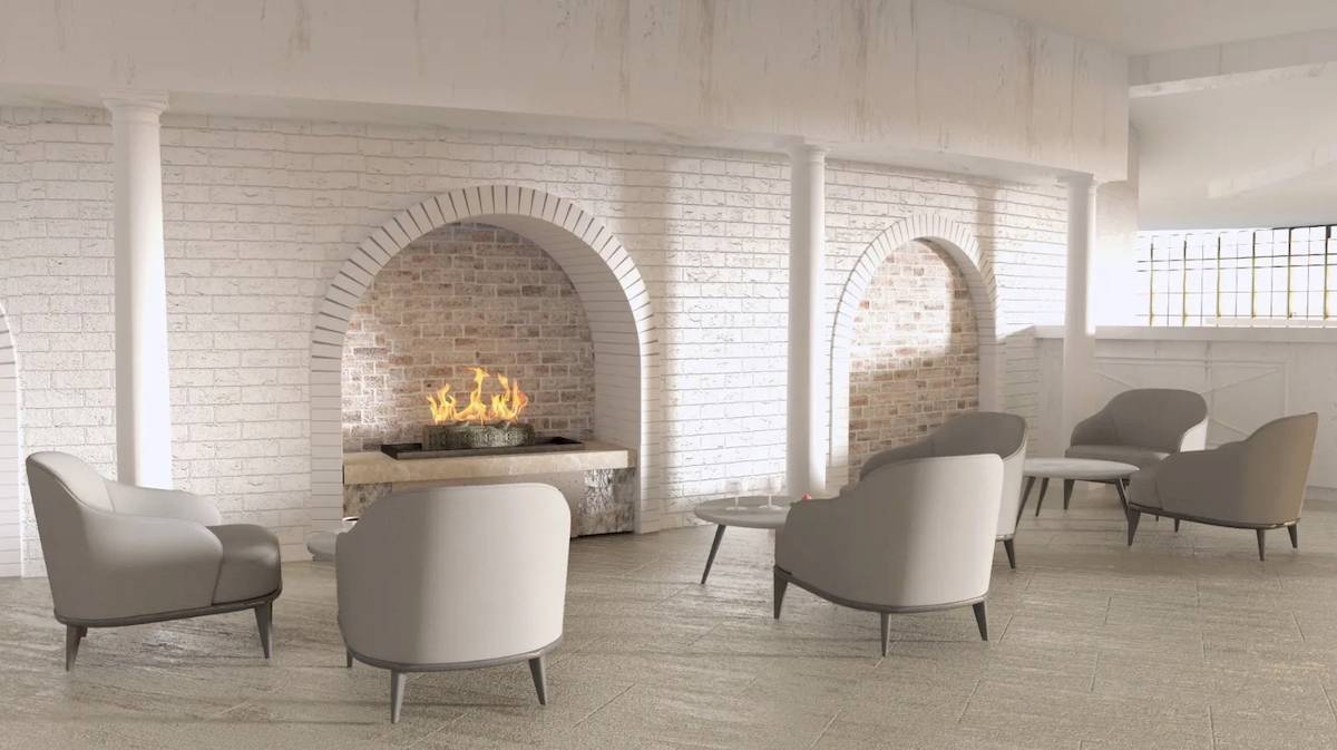 Loungebereich des Sunrise Queen Luxury Hotel mit weißen Sesseln und einem Kamin.