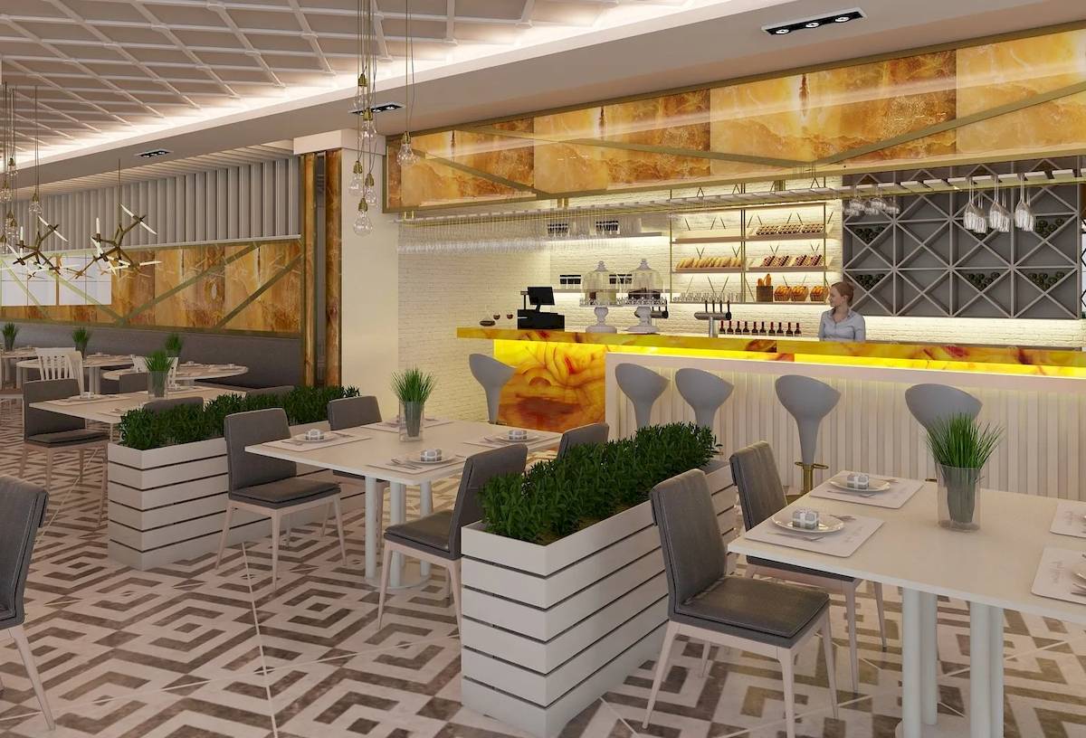 Innenansicht des Restaurants des Sunrise Queen Luxury Hotel mit weißen Tischen, Stühlen und einer Theke.