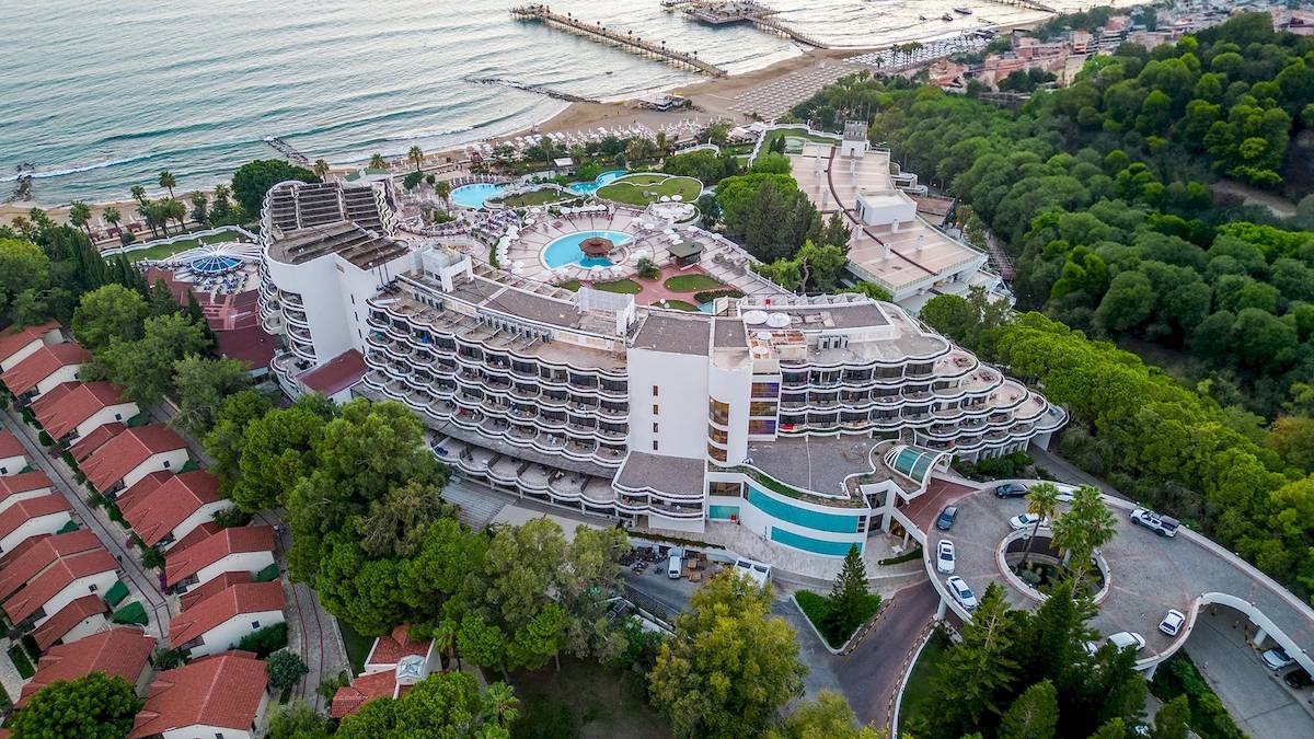 Luftaufnahme des Sunrise Queen Luxury Hotel mit mehreren Swimmingpools und einer Küstenlinie im Hintergrund.