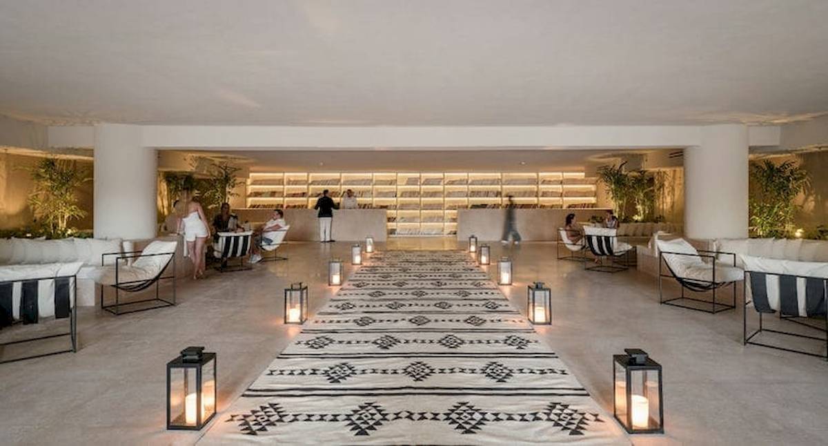 Serry Beach Resort Lobby mit gemustertem Teppich, Leuchten und Gästen.