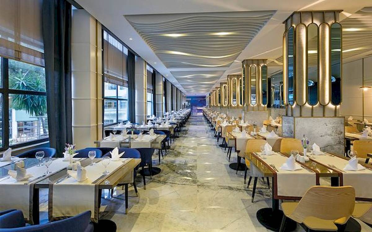 Innenansicht des Restaurants im Limak Atlantis Deluxe Hotel & Resort mit gedeckten Tischen und modernem Interieur.