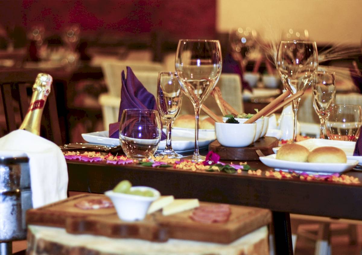 Vonresort Golden Beach Speisetisch mit Wein, Brot, Käse, Schinken und Oliven.
