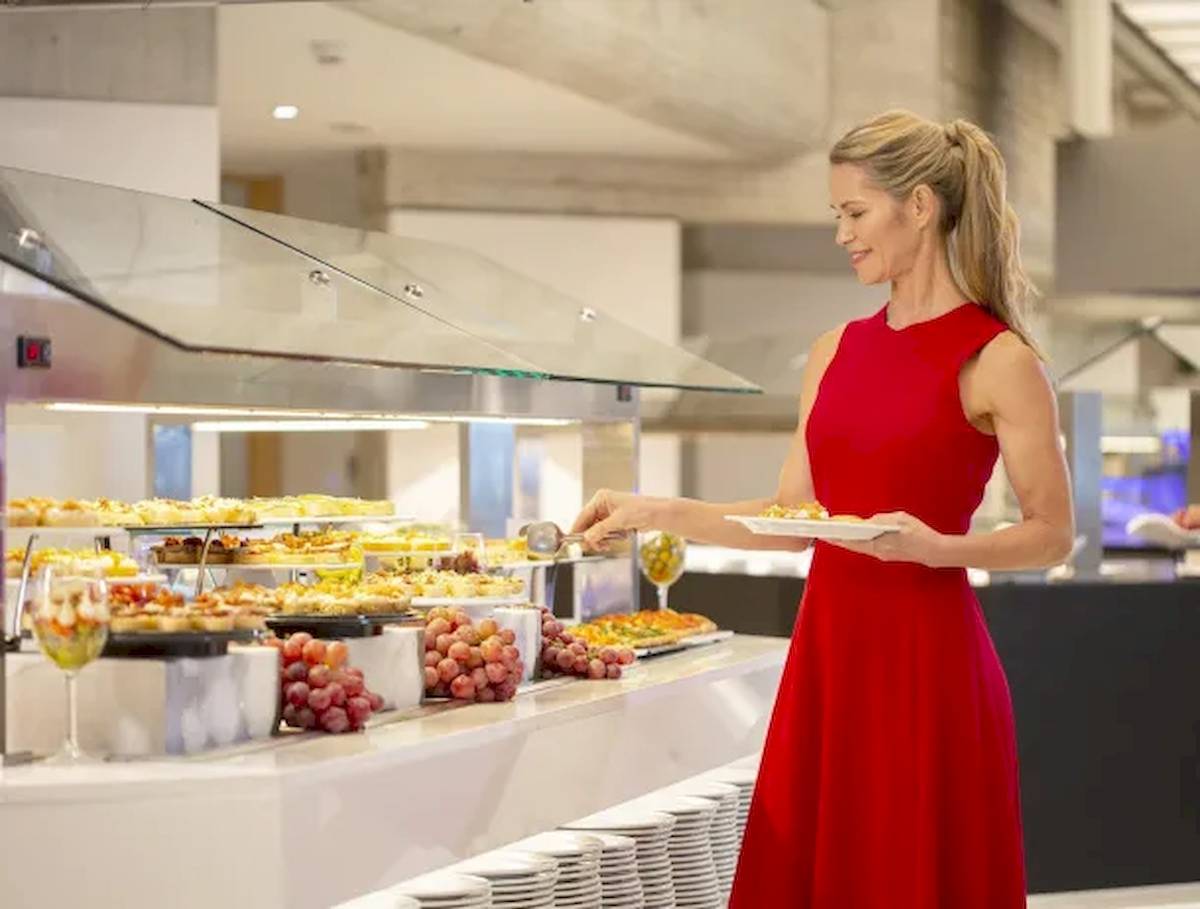 Frau im roten Kleid bedient Buffet im Hipotels Mediterraneo