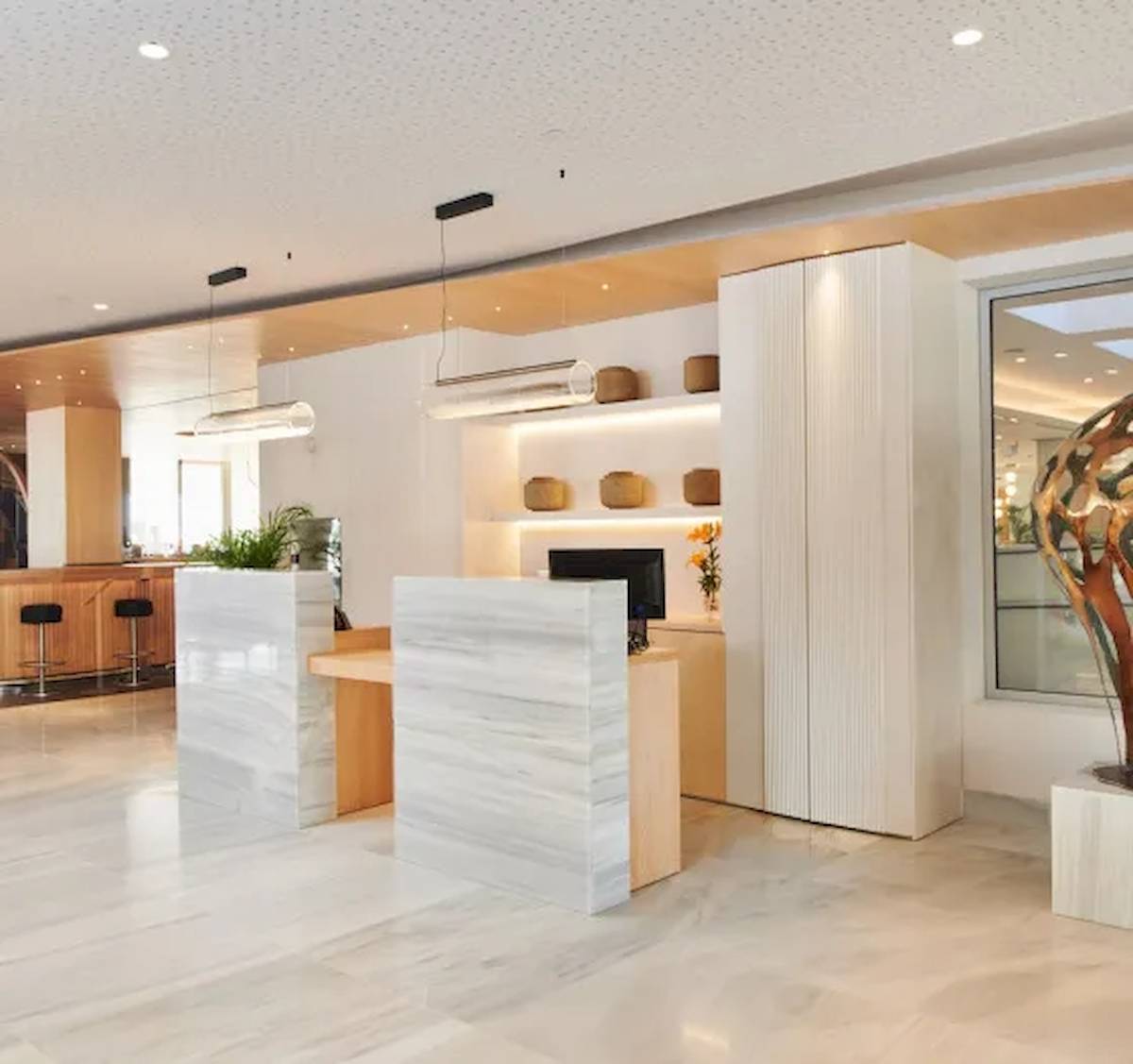 Reception im Hipotels Mediterraneo mit weißen Marmor und moderner Einrichtung.
