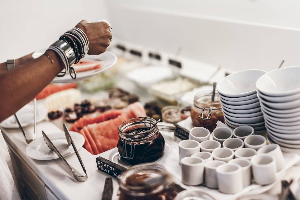 Frühstücksbuffet im Mykonos Theoxenia Boutique Hotel mit Früchten, Marmeladen und Tassen.