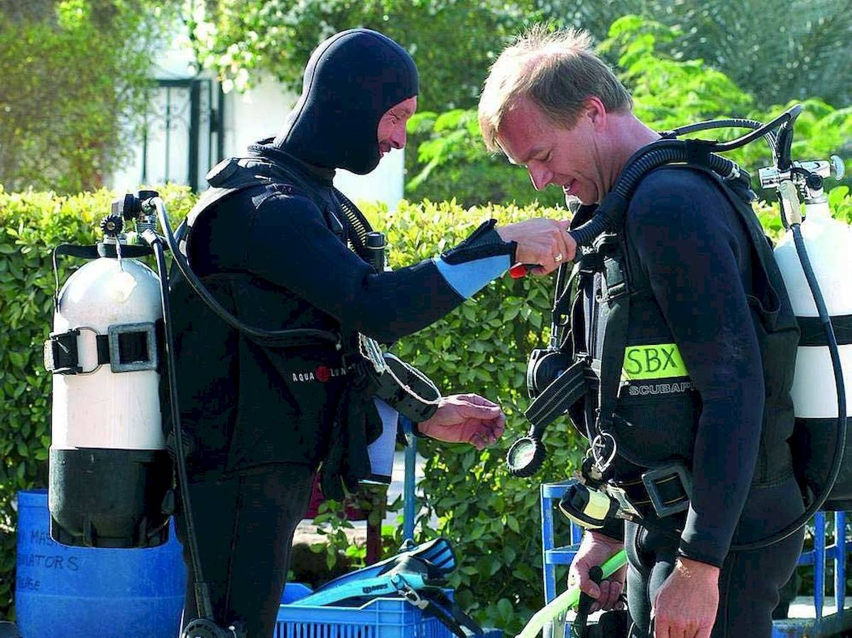 Zwei Taucher bereiten sich im Maritim Jolie Ville Resort vor, einer mit Aqualung-Ausrüstung.