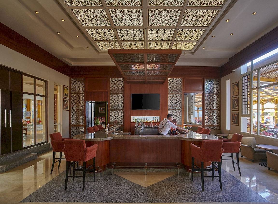 Bar im Maritim Jolie Ville Resort & Casino Sharm El Sheikh mit rotem Stuhlkreis und Theke.