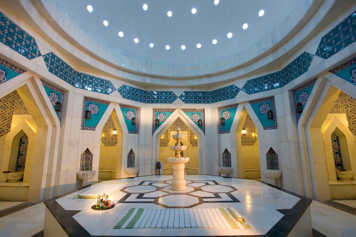 Innenansicht des Badebereichs im Sentido Kamelya Selin Hotel mit zentralem Springbrunnen und dekorativen Wandmustern.