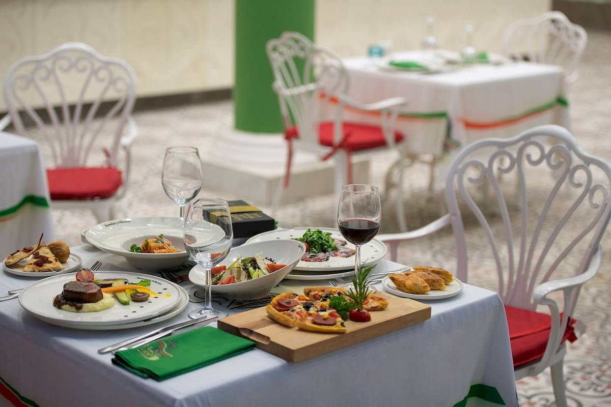 Gedeckter Speisetisch im Sentido Kamelya Fulya Hotel mit verschiedenen Gerichten und Weingläsern.