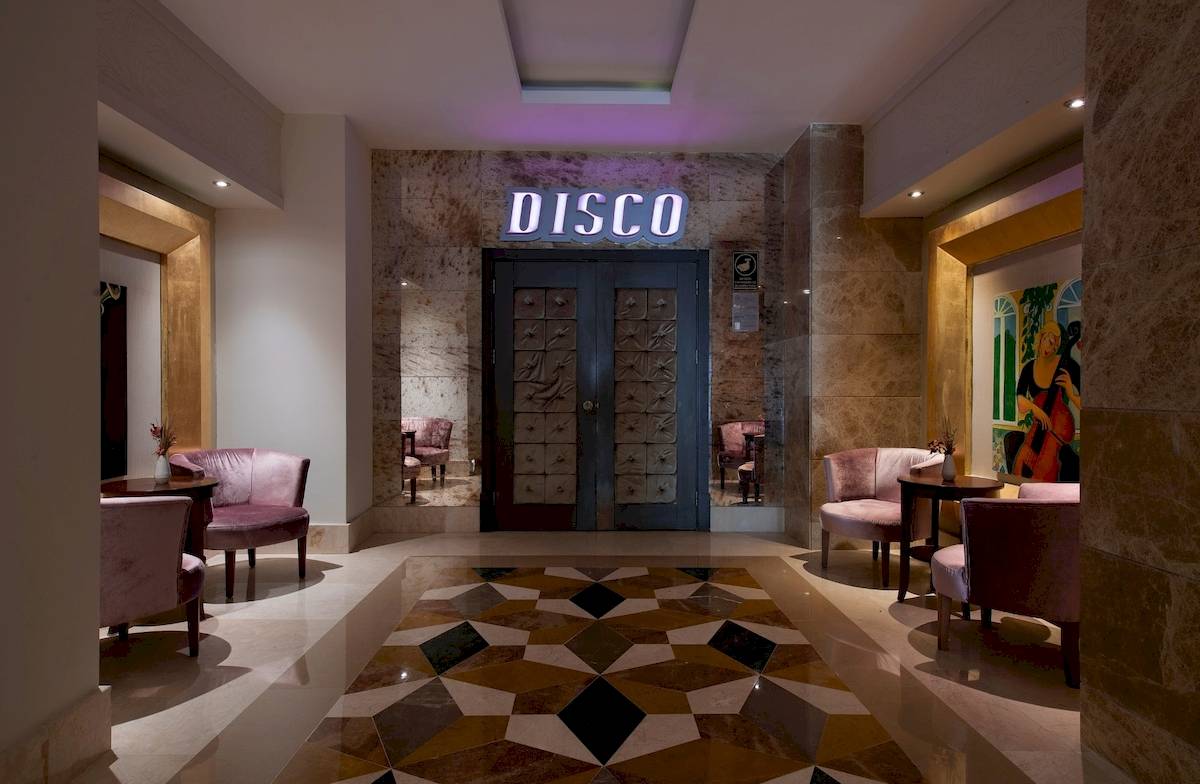 Der Disco-Eingang des Sentido Kamelya Fulya Hotels mit geometrischem Bodenmuster und leuchtendem Disco-Schild.