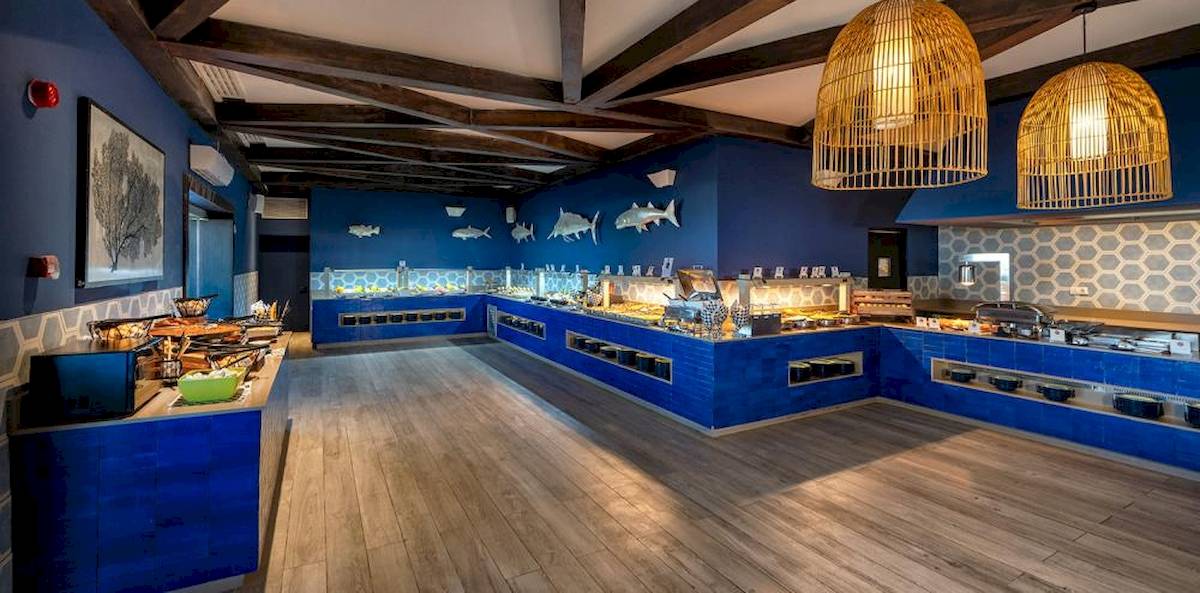 Buffetbereich im Lopesan Costa Bavaro Resort Spa & Casino mit blauen Wänden und Holzboden.