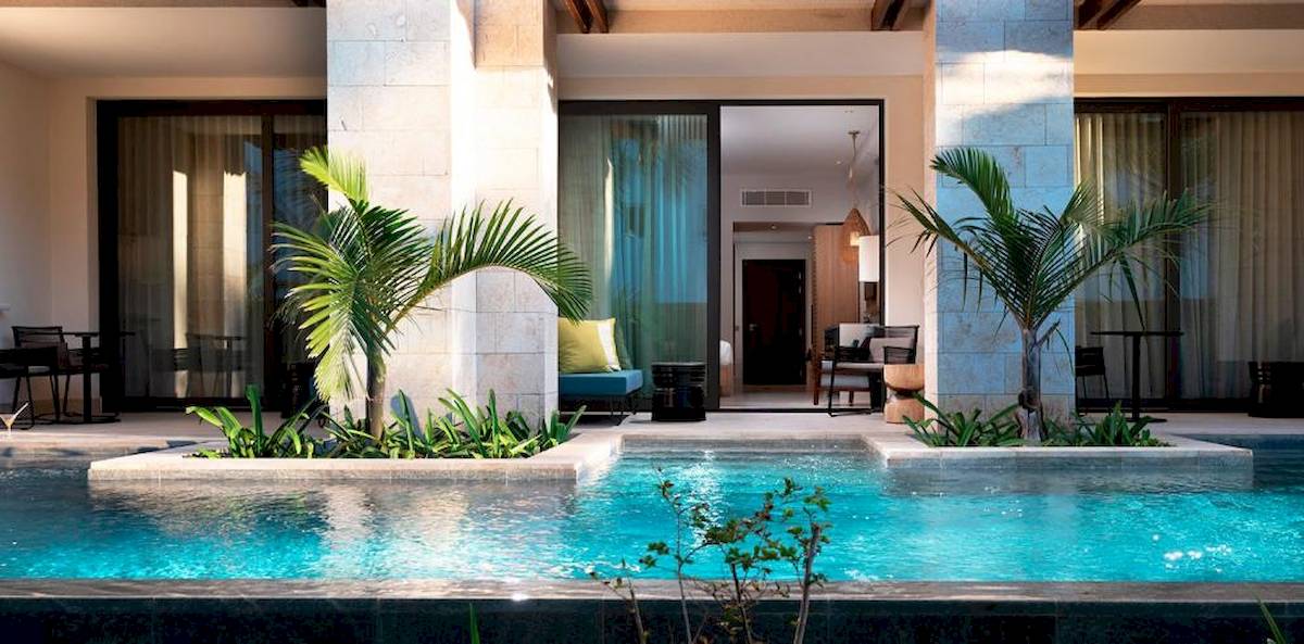 Außenpool des Lopesan Costa Bavaro Resort Spa & Casino mit Pflanzen und Möbeln