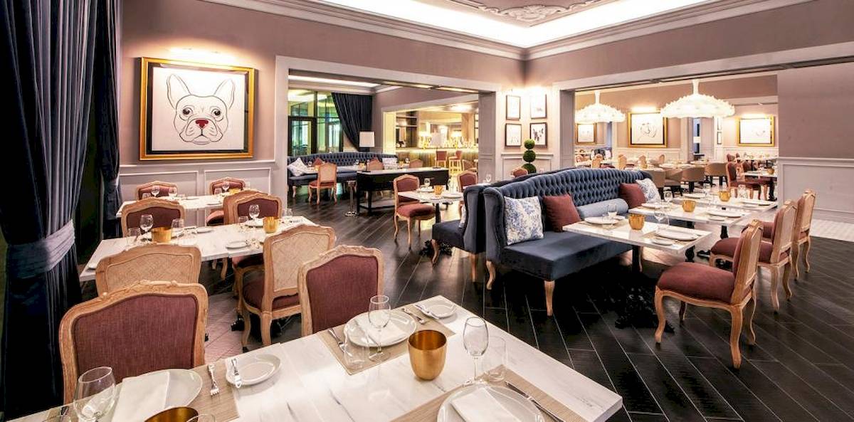 Innenansicht des Restaurants im Lopesan Costa Bavaro Resort Spa & Casino mit gedeckten Tischen und Stühlen.