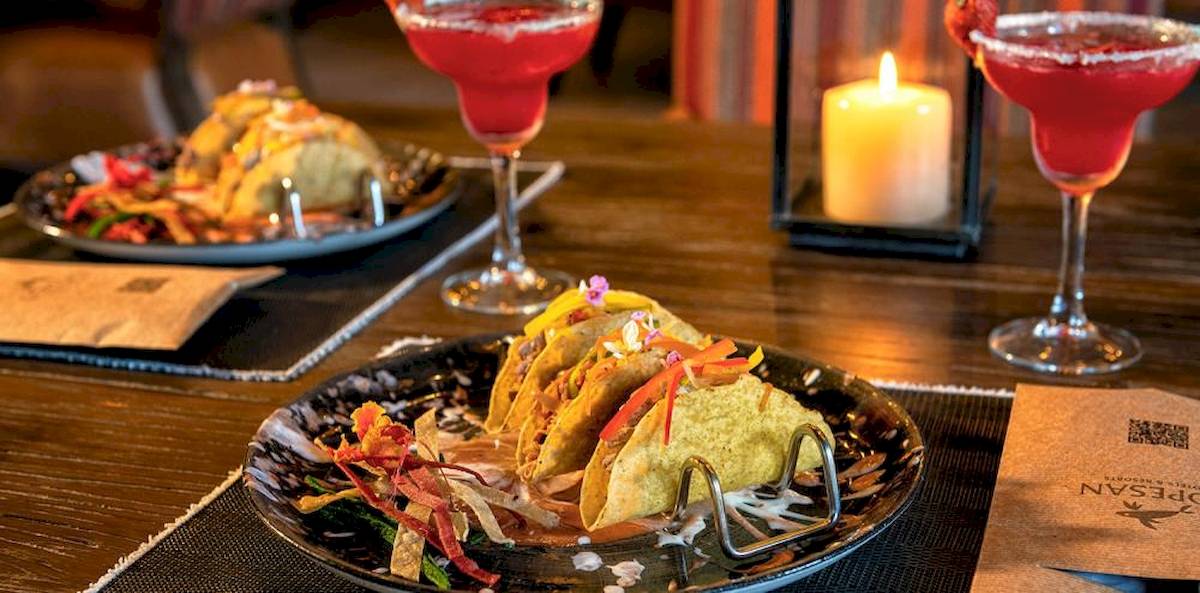 Ein Tisch mit zwei Tellern voller Tacos und Getränken im Lopesan Costa Bavaro Resort Spa & Casino.