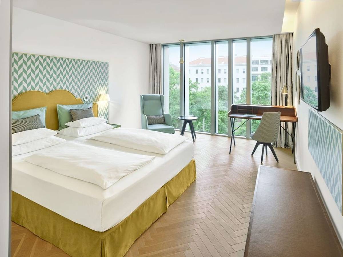 Doppelbett Zimmer im MAXX by Steigenberger Vienna mit zeitgenössischem Design und Blick auf die Stadt.