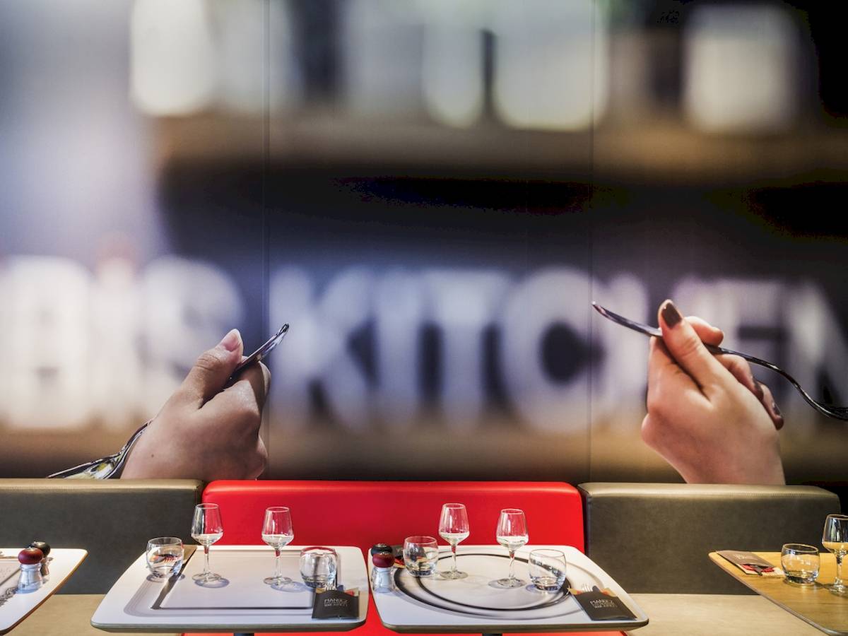 Foto des Ibis Wien Mariahilf Restaurants mit Tisch und Geschirr im Vordergrund