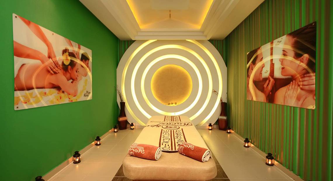 Spa-Behandlungsraum im Pickalbatros Palace Resort, Hurghada mit grünen Wänden, zwei großen Bildern und einer zentralen Lampe.