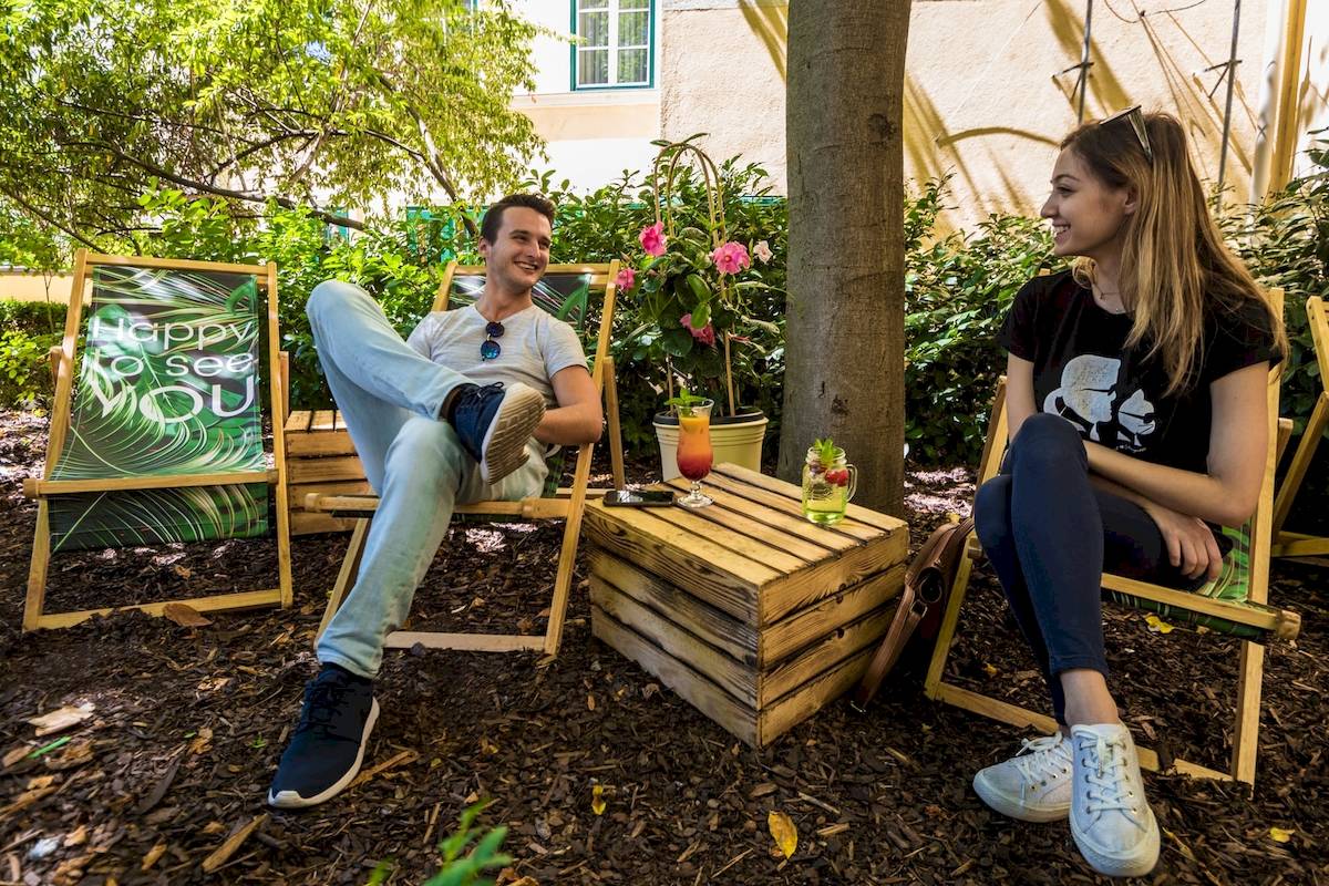 Gäste sitzen in der Gartensitzecke des Mercure Grand Hotel Biedermeier