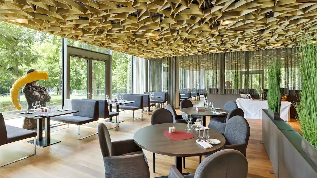 Innenansicht des Restaurants im DoubleTree by Hilton Wien Schonbrunn mit geometrischer Deckengestaltung und modernen Möbeln.