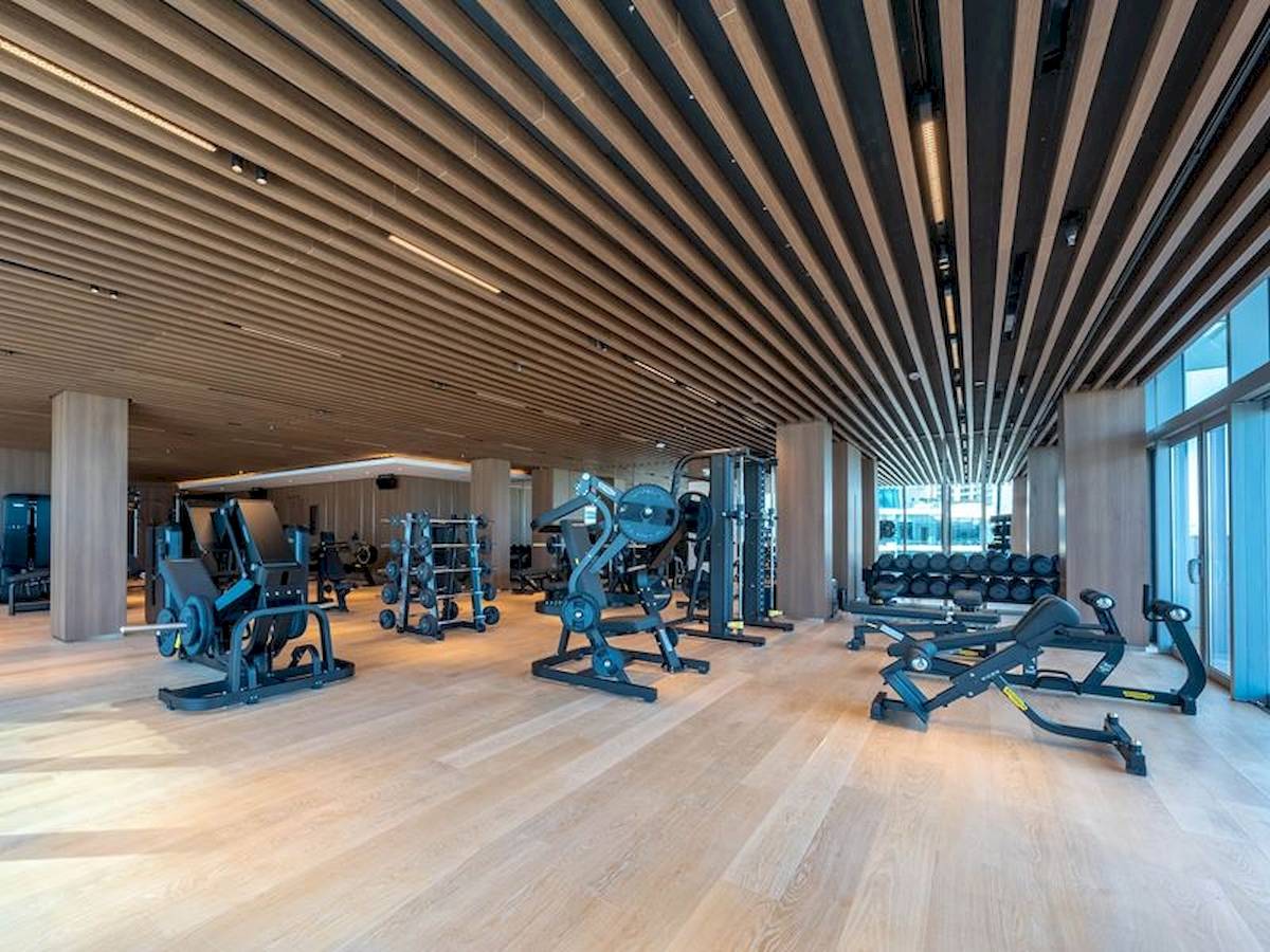 Fitnesscenter im Five Luxe JBR Hotel mit modernen Geräten und Holzboden.