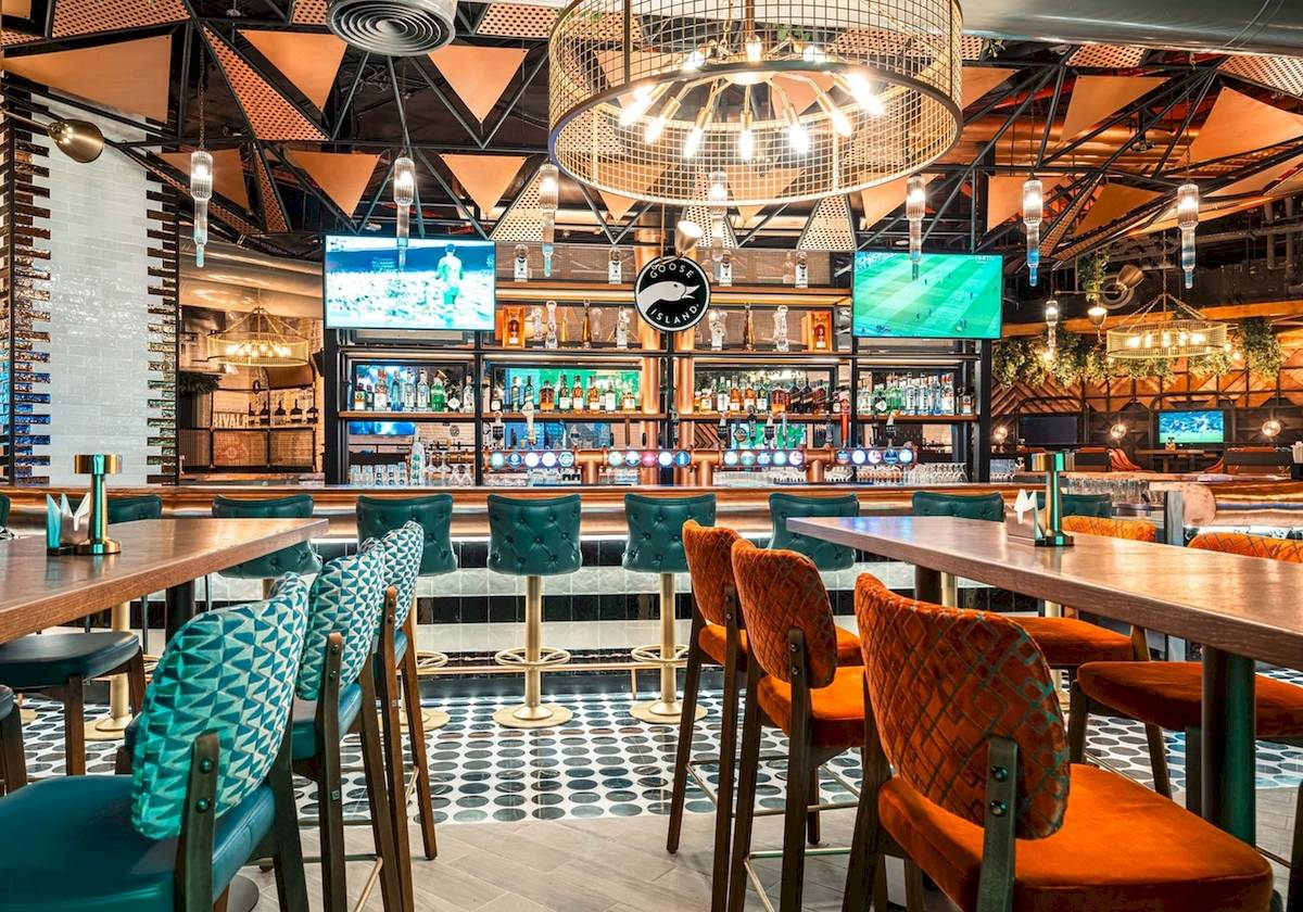 Innenansicht der Bar im FIVE LUXE JBR Hotel mit Barhockern und Tisch.