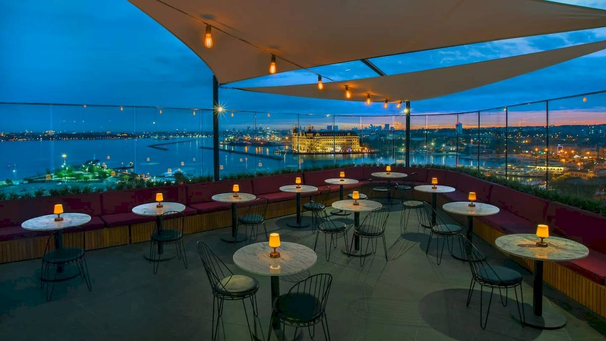 Außenbereich des Doubletree by Hilton Istanbul Moda bei Nacht mit Blick auf die Stadt und den Hafen.
