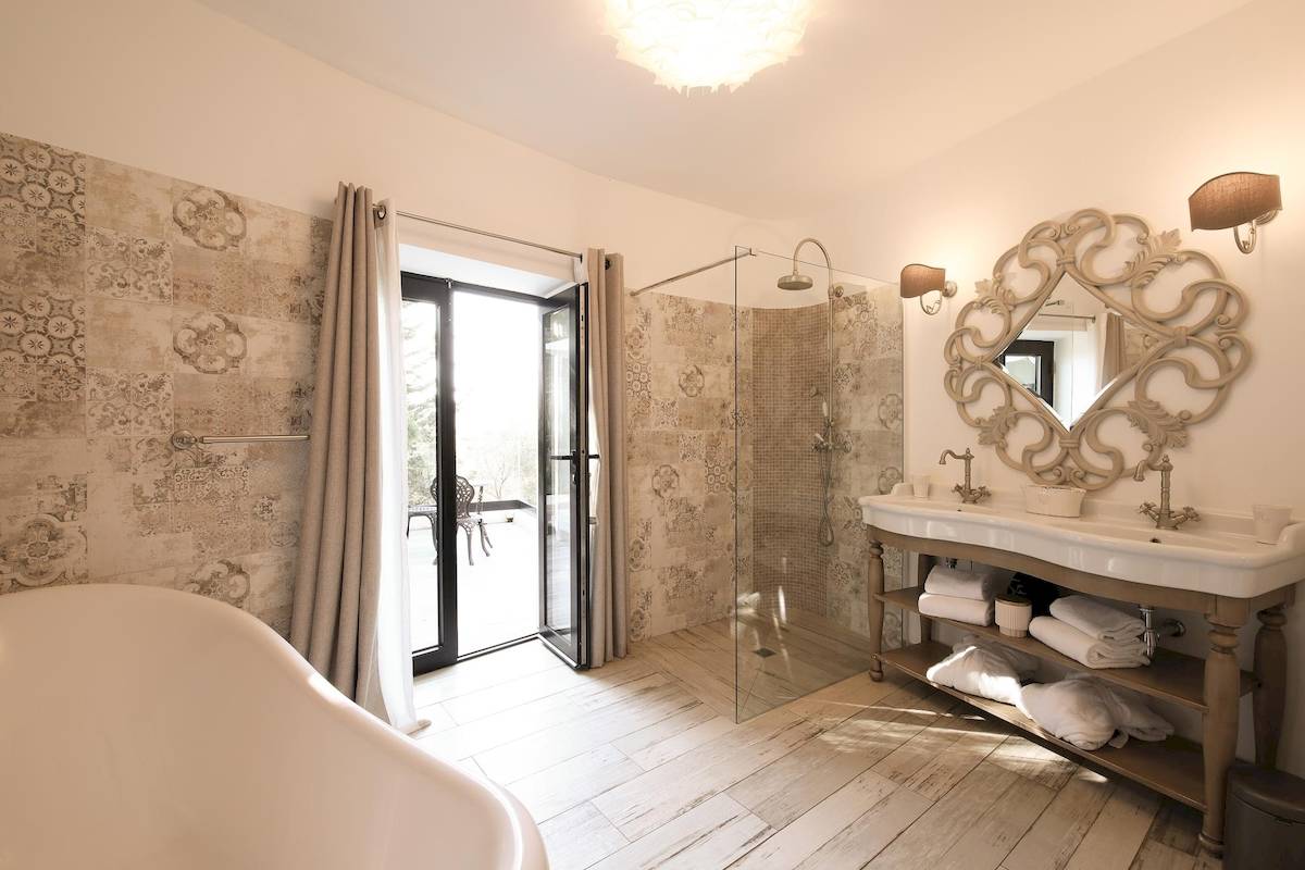 Badezimmer mit Badewanne, Dusche, Waschbecken und Holzboden, L'Hostellerie du Moulin
