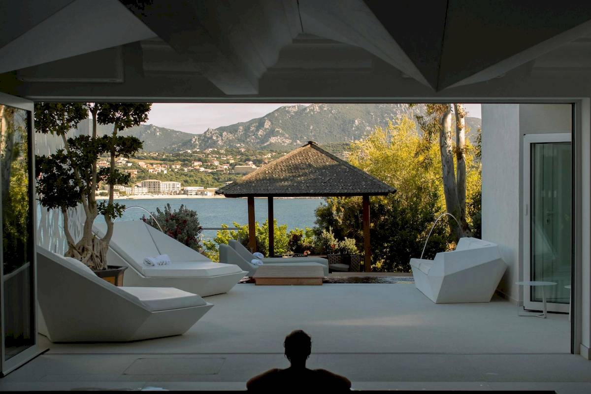 Innenansicht der Terrasse von L'Hostellerie du Moulin mit Blick auf das Meer und Berge.
