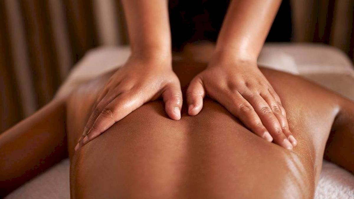 Massage im Hotel La Lagune mit Händen auf dem Rücken einer Person.