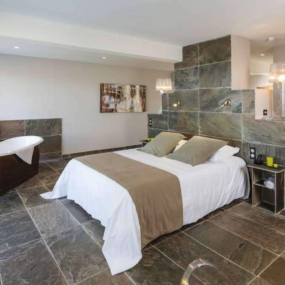 Schlafzimmer im Hotel La Lagune mit einem großen Bett und Badewanne