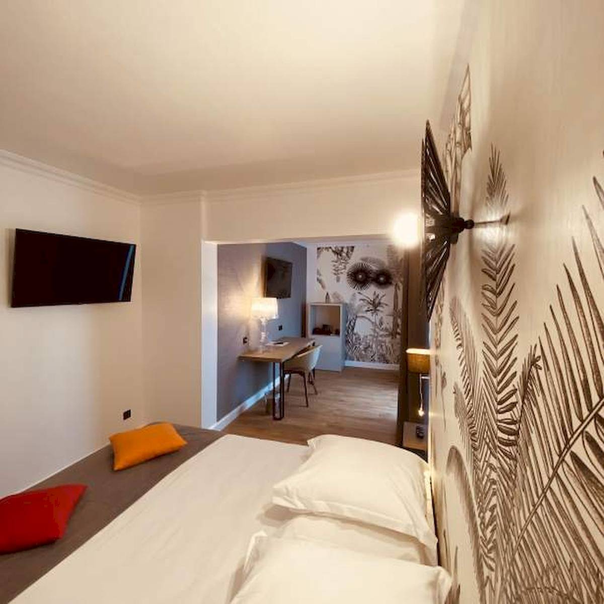 Schlafzimmer im La Lagune Hotel mit Bett, Fernseher und Schreibtisch.