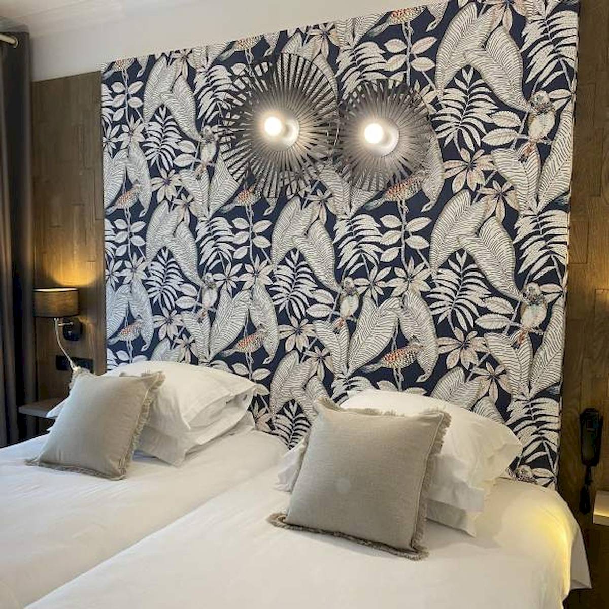Doppelbett im La Lagune Hotel mit tropischem Wanddesign und Lampen