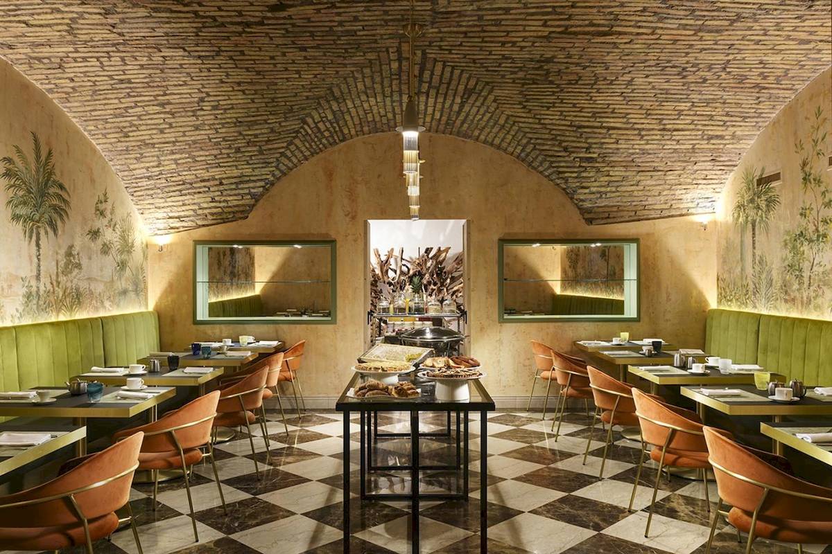 Innenbereich des Restaurants Leon's Place mit gemustertem Boden und runden Tischen.
