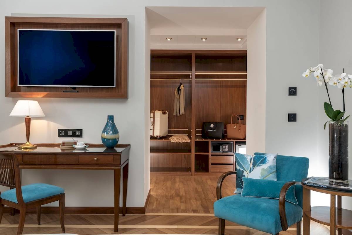 Innenansicht eines Zimmers im Bettoja Hotel Mediterraneo mit Schreibtisch, Fernseher und Schrank.