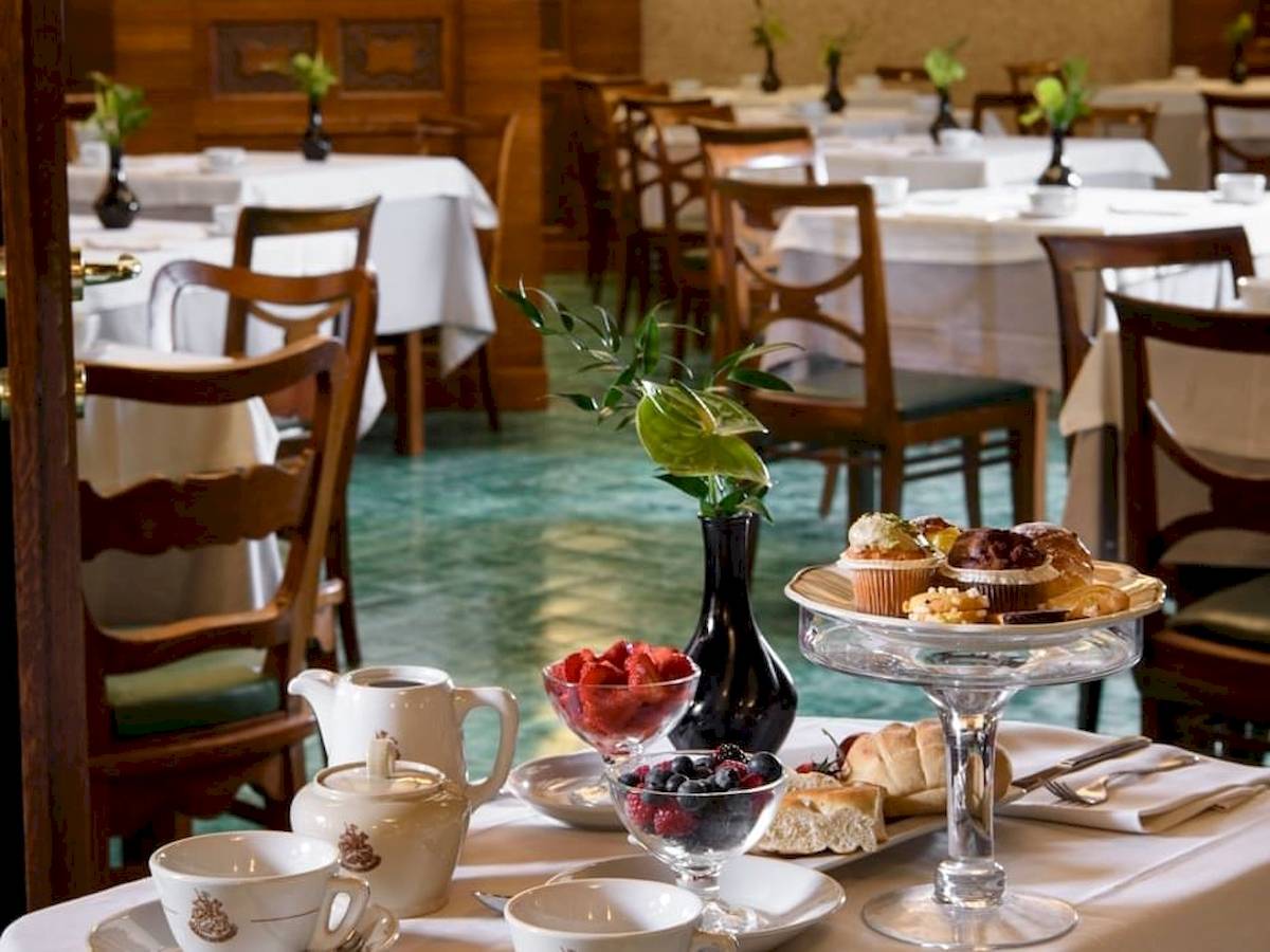 Frühstückstisch im Bettoja Hotel Mediterraneo mit Gebäck, Früchten und Kaffee.