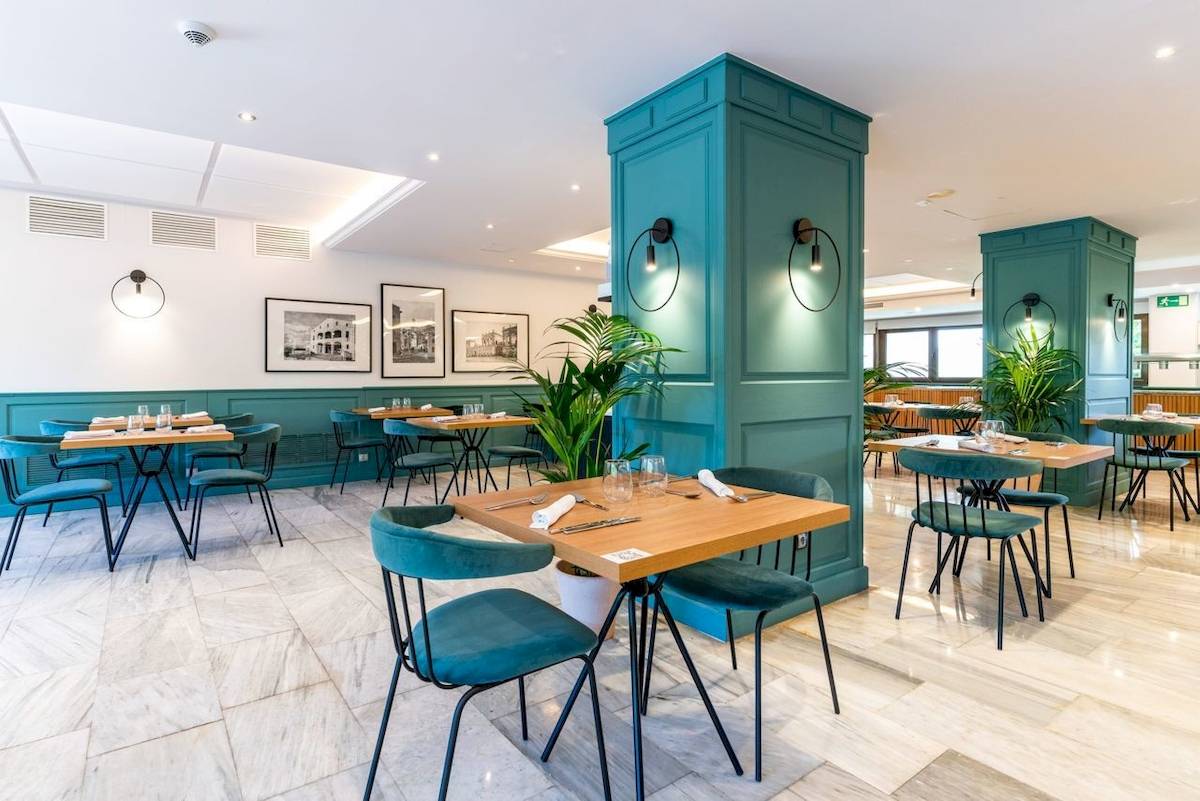 Innenansicht des Restaurants im ARTIEM Audax Hotel mit blauen Stühlen und Tischen.