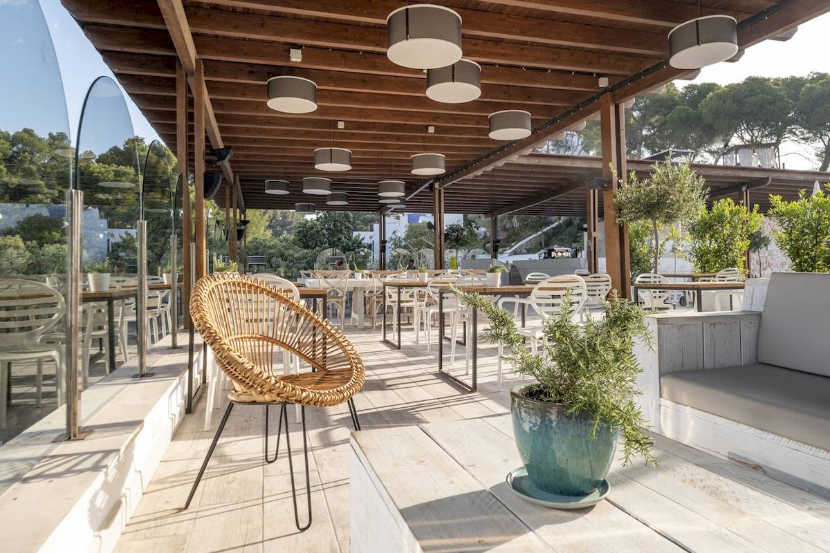 Terrasse des ARTIEM Audax Hotels mit Tischen, Stühlen und Pflanzen.