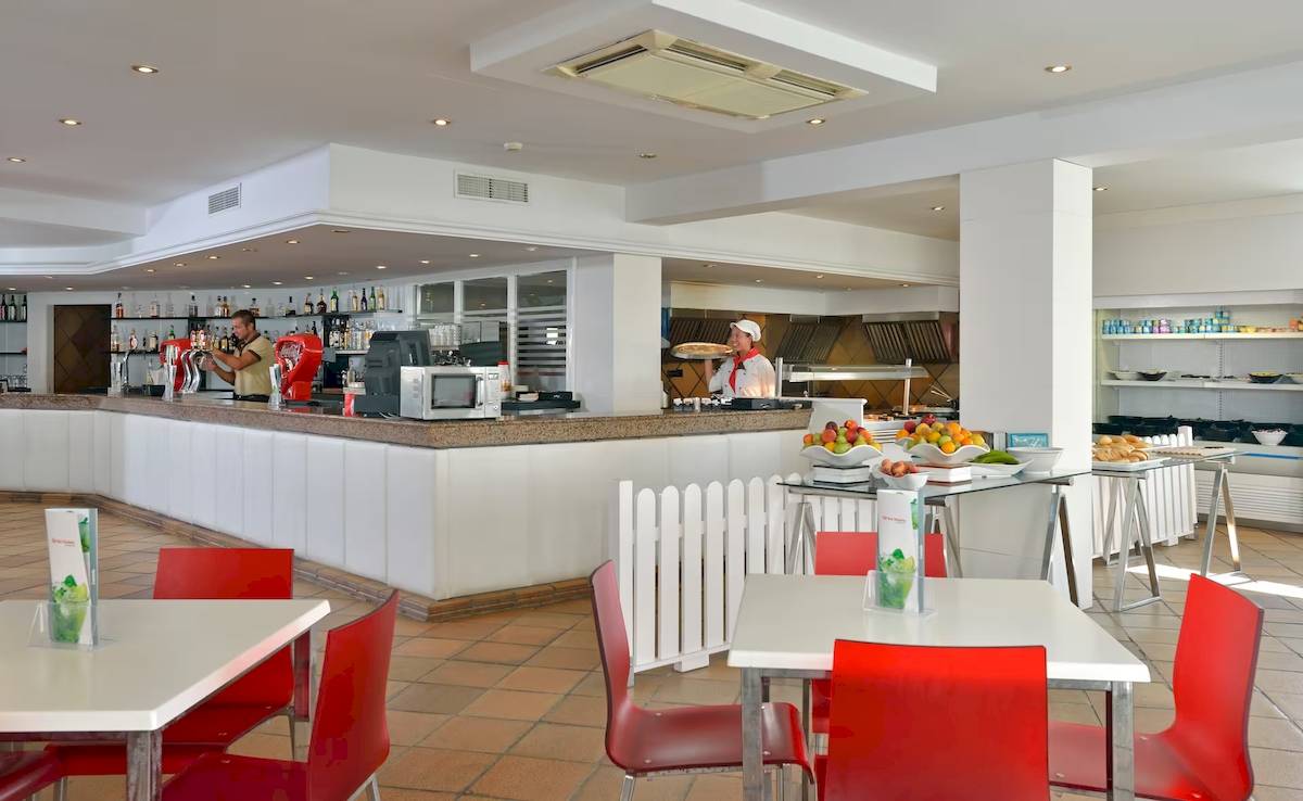 Rezeptionsbereich des Sol Milanos Pinguinos Hotels mit Bar und Frühstücksbuffet.