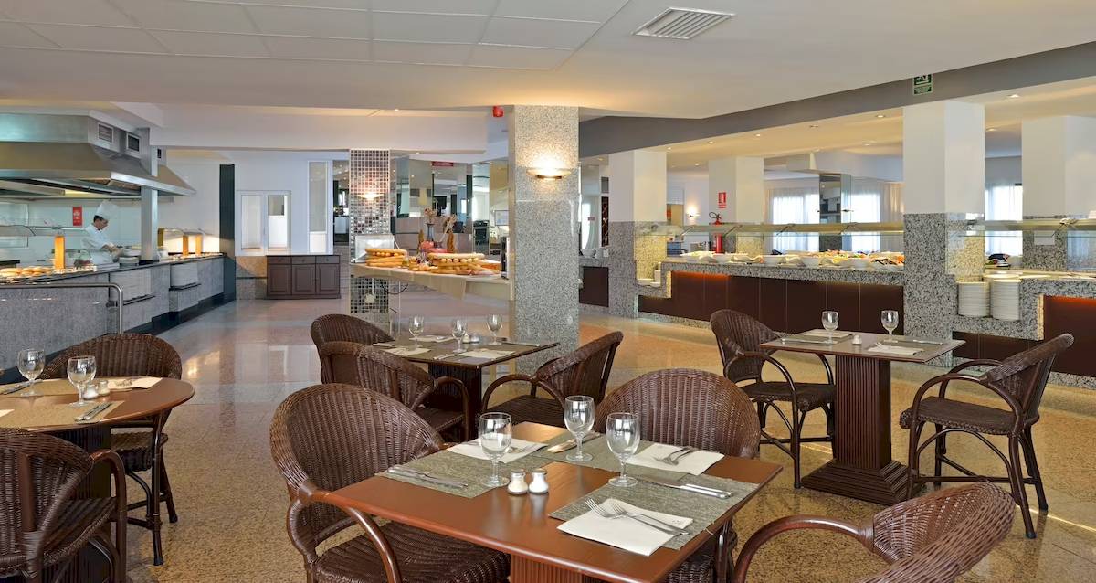 Innenbereich des Restaurants im Sol Milanos Pinguinos Hotel mit Tischen, Stühlen und Essensbereich