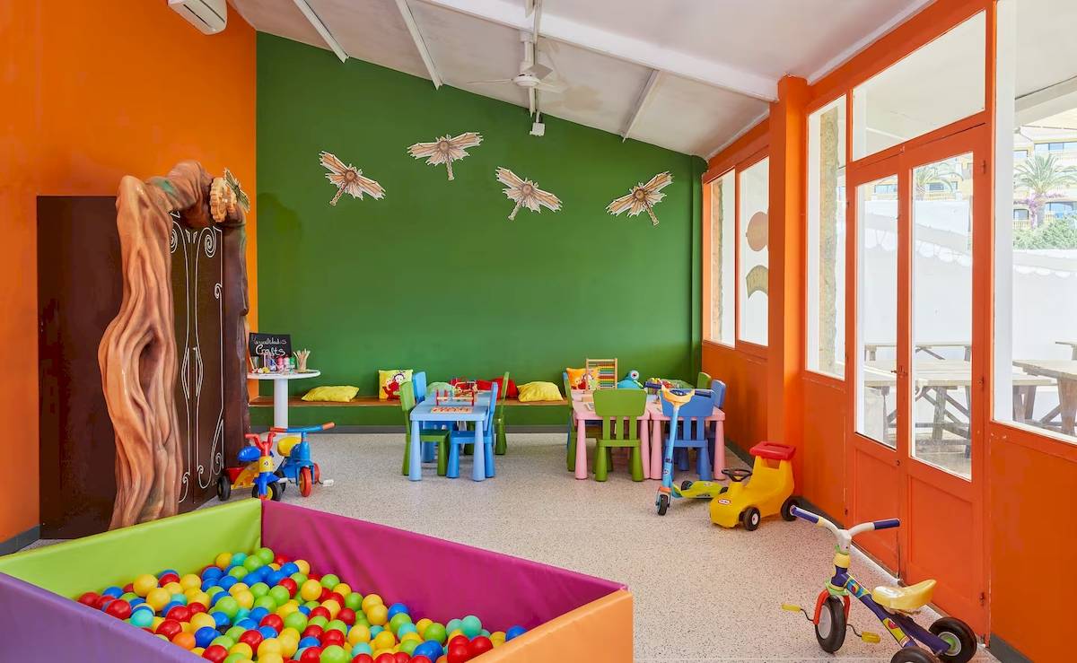 Kinderspielzimmer im Sol Milanos Pinguinos mit bunten Wänden, Tischen, Stühlen und Spielzeug.