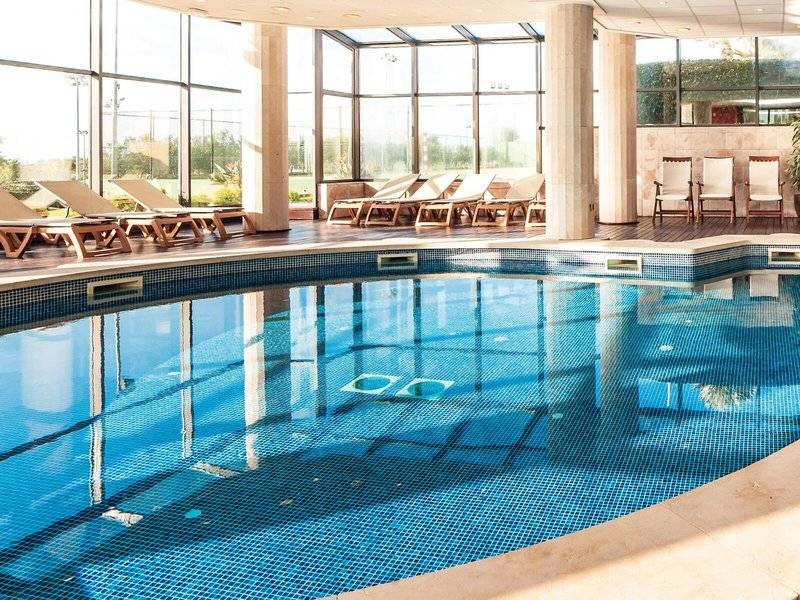 Innenpool des Punta Prima Resort & Spa mit Lounge-Sesseln und Glaswänden