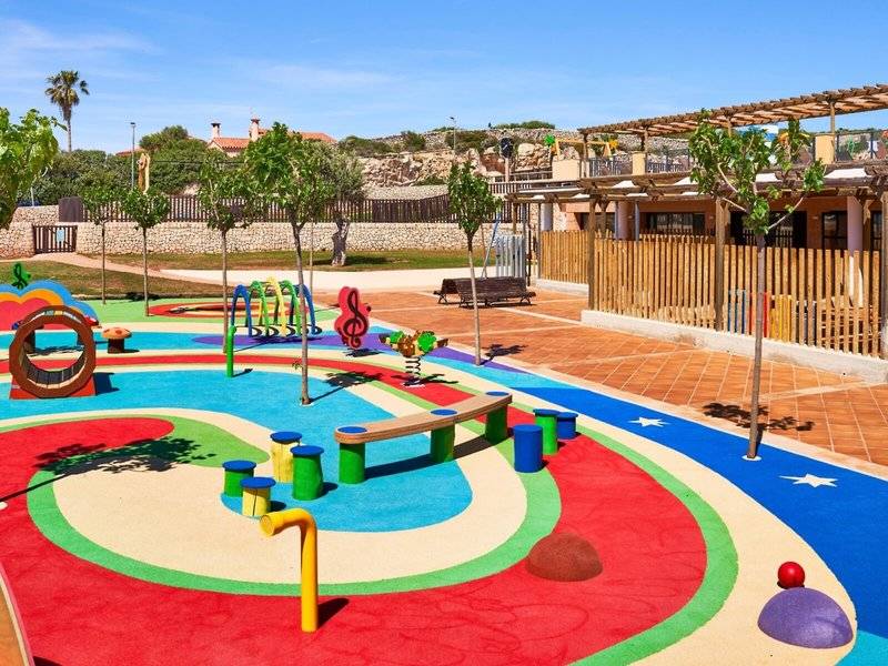 Kinderspielplatz im Freien mit bunten Spielgeräten und Bäumen, Punta Prima Resort & Spa